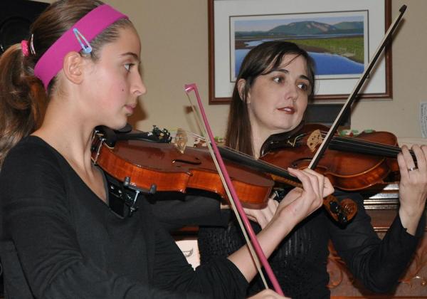 Young teen in a hot pink headband playing a violin duet with Rhiannon