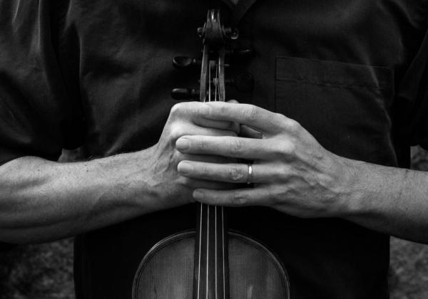 Black & White photo of Don MacDonald Holding a Violin with both hands