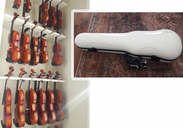 rack of various sized violins and a white shiny violin case on a rug