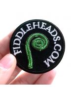 Fingers holding a detailed Fiddleheads.com Embroidered Iron-On Patch