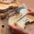 Luthier hands holding pieces of an unfinished violin on a workbench.