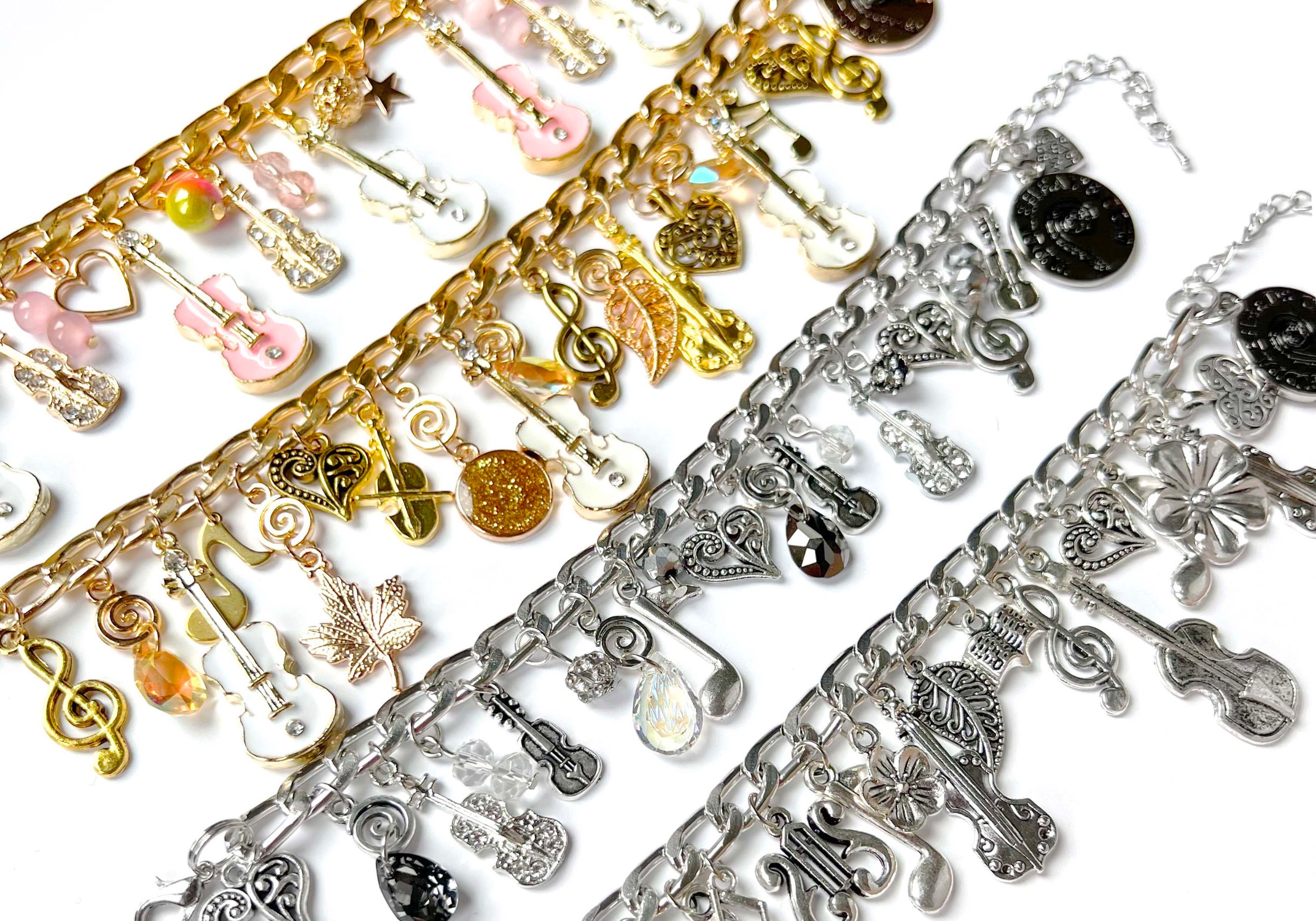 four types of charm bracelets in silver and gold featuring violins, music symbols, crystals and other ornate beads and charms