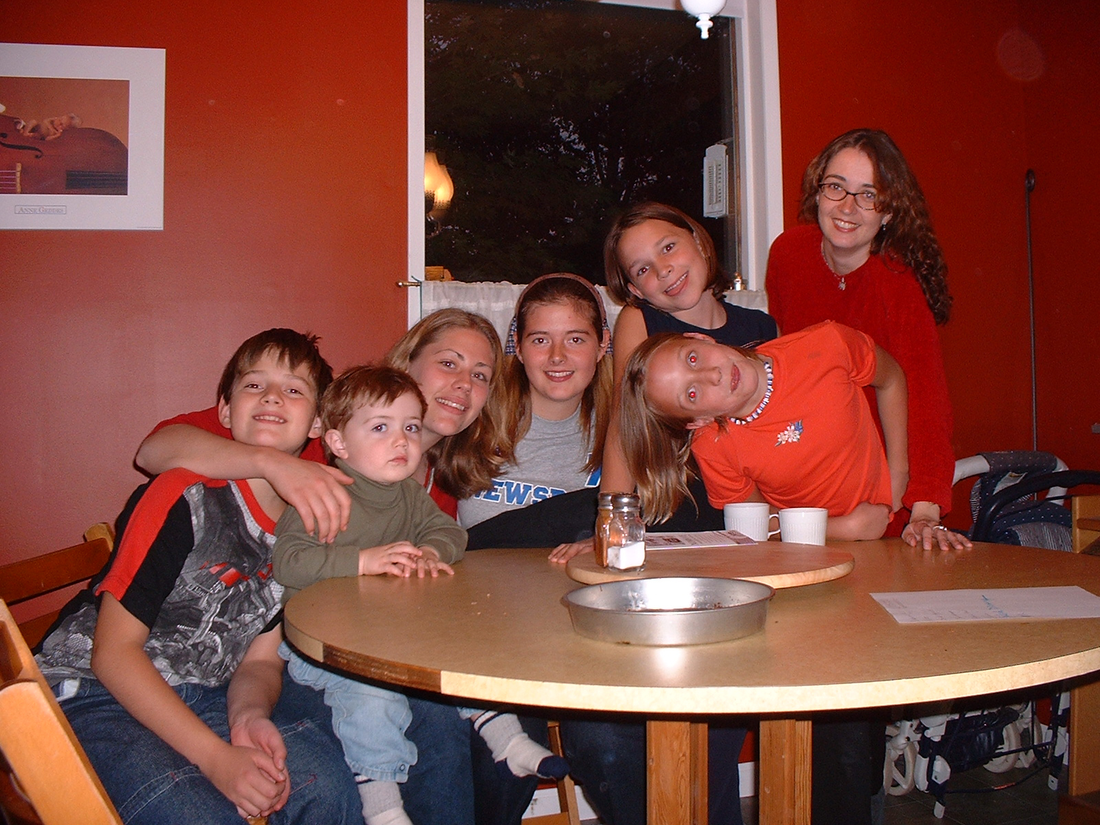 Rhiannon and her toddler daughter with a few students at a kitchen table