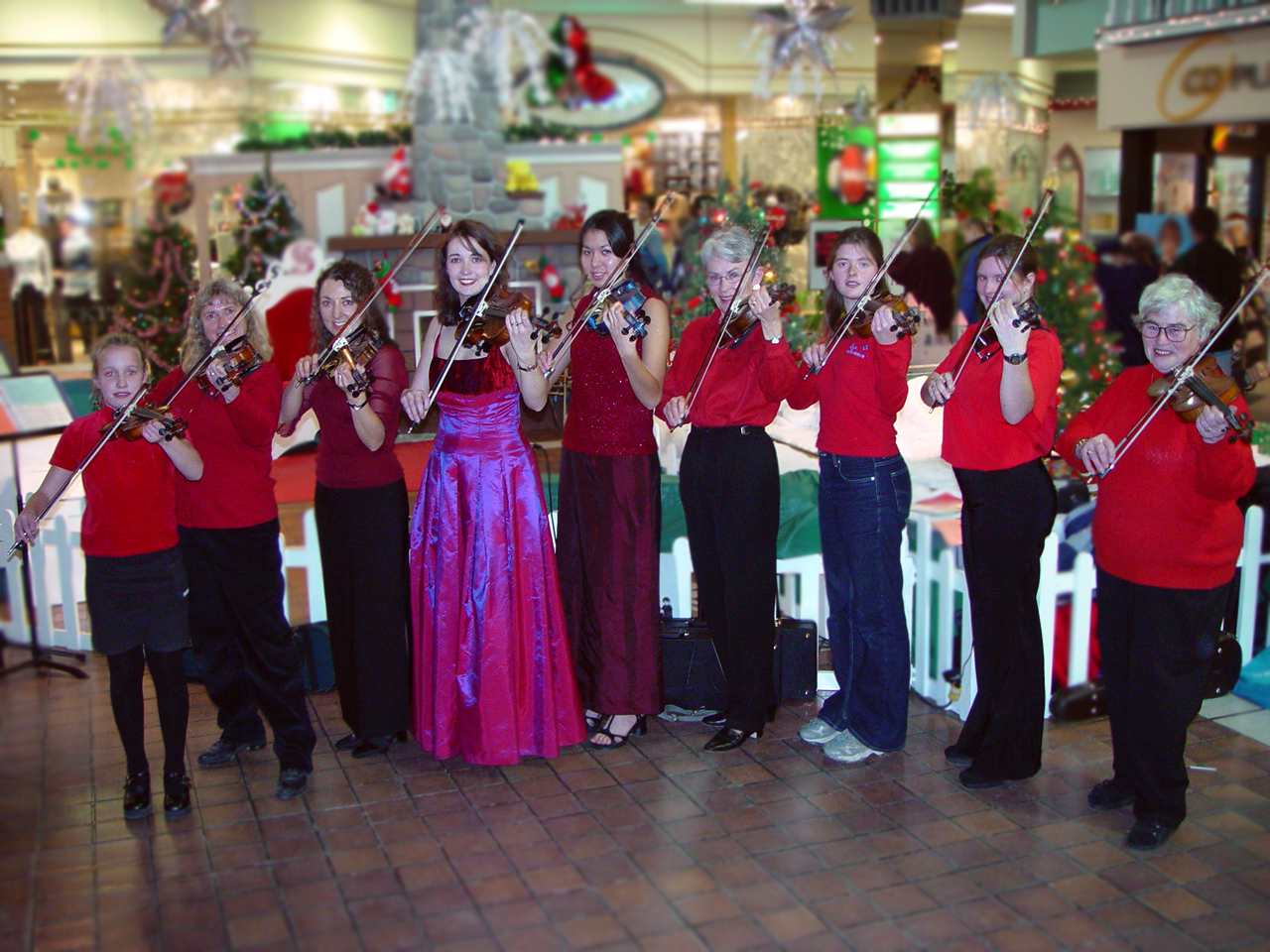 Young Rhiannon and her students wearing red and performing at a mall at Christmas in 2002