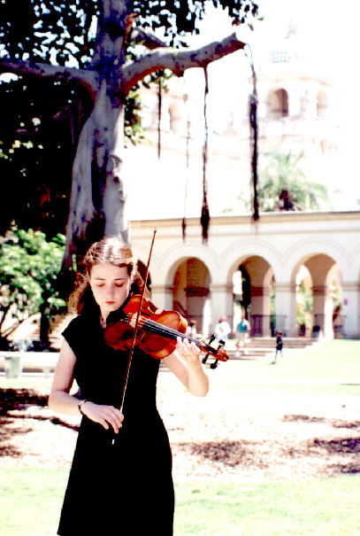 Rhiannon playing violin in front of the Botanical Gardens at Balboa Park