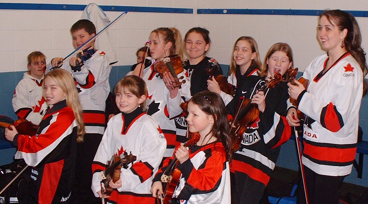 Rhiannon and her students play violin in hockey jerseys