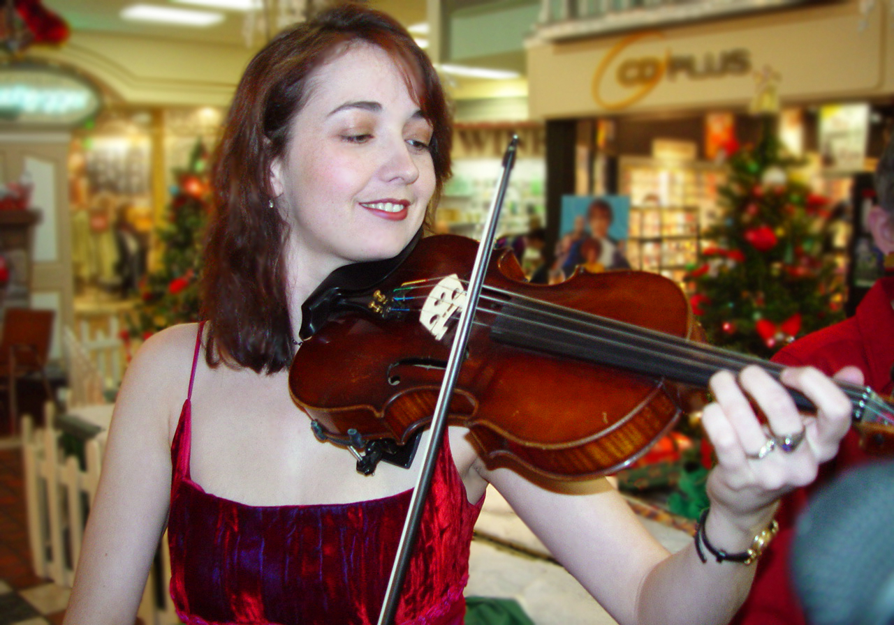 Young Rhiannon playing violin at the mall in 2002