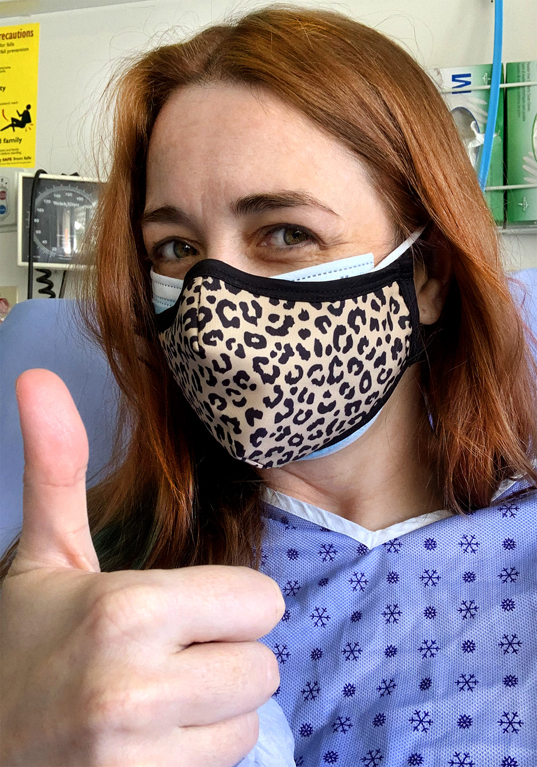 Rhiannon wearing two masks and a hospital gown doing thumbs up