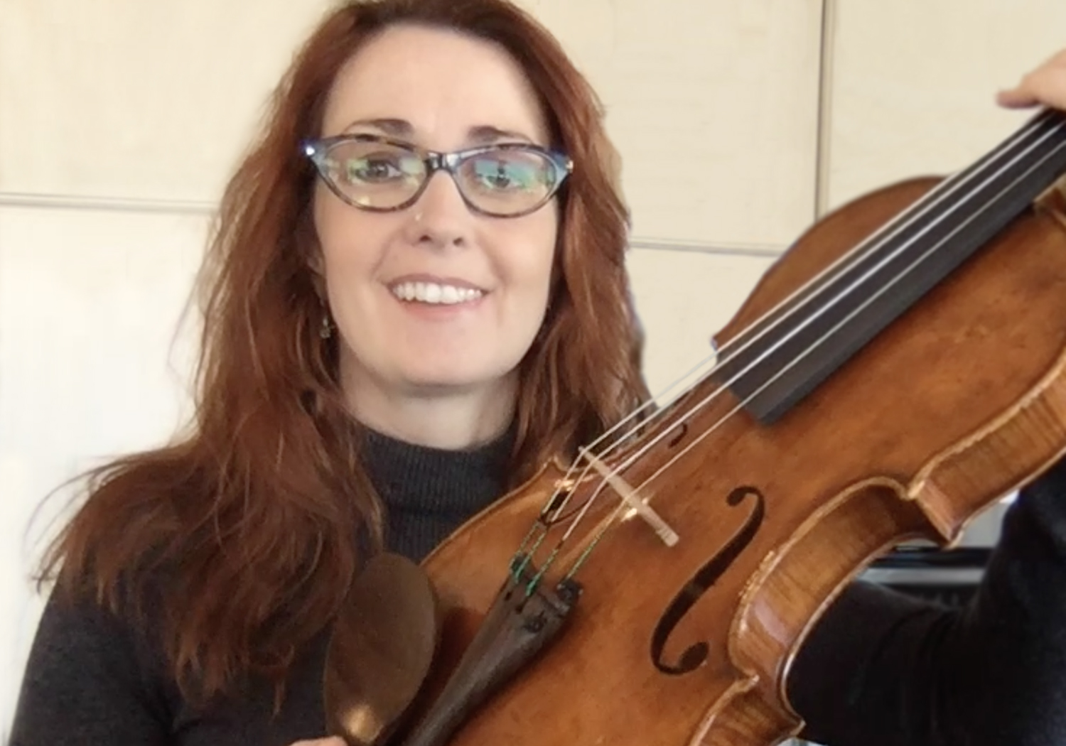 Rhiannon Nachbaur holding up a Violin to the camera