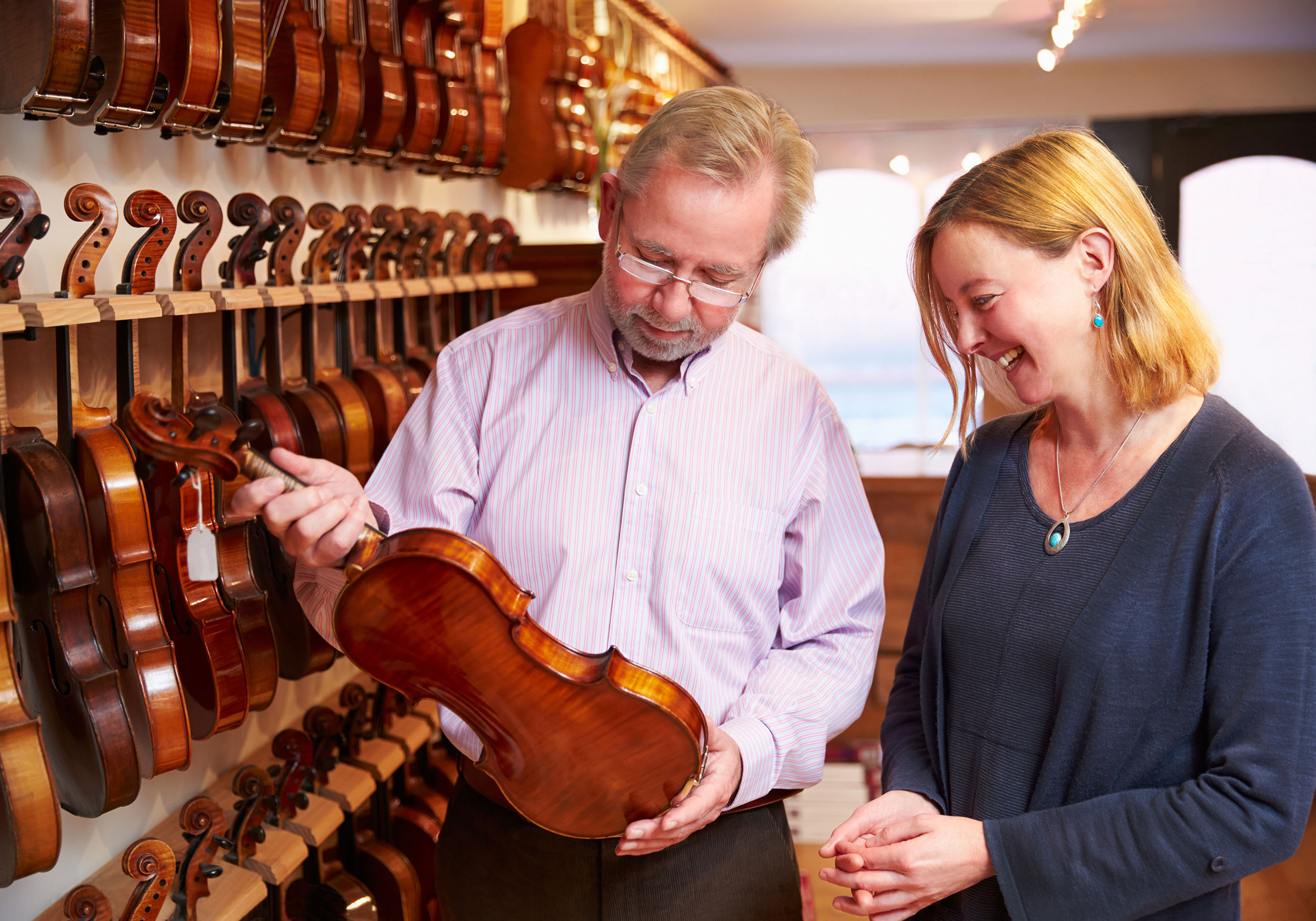 Man and woman considering a violin in a shop