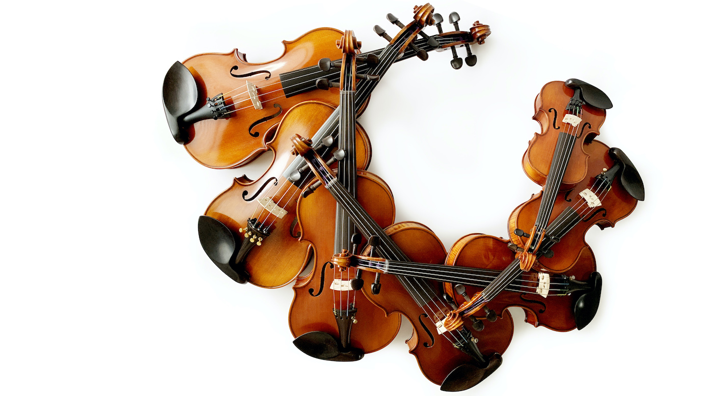 lots of violins stacked on top of each other 