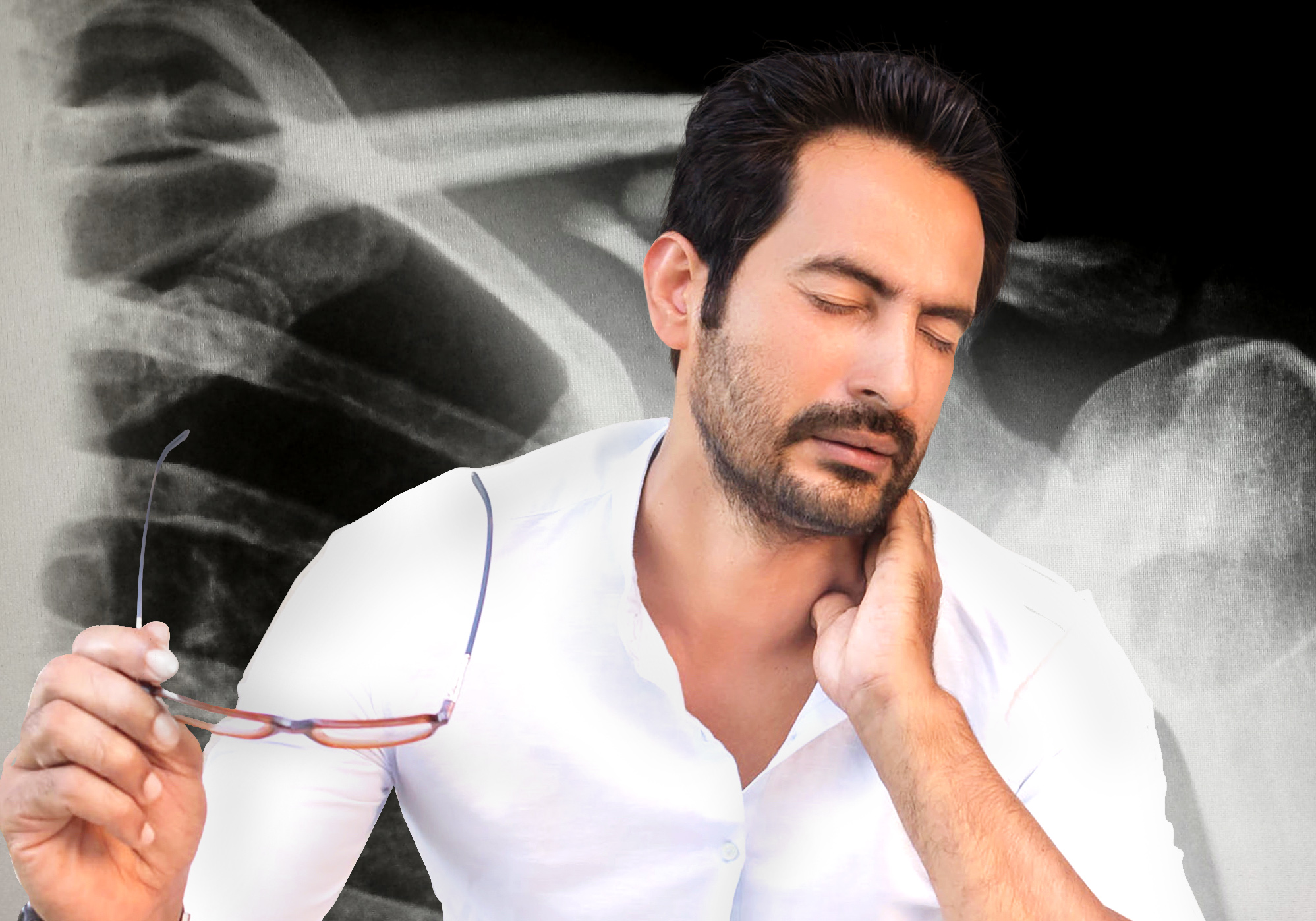 Man in front of Xray cringing from sore neck 