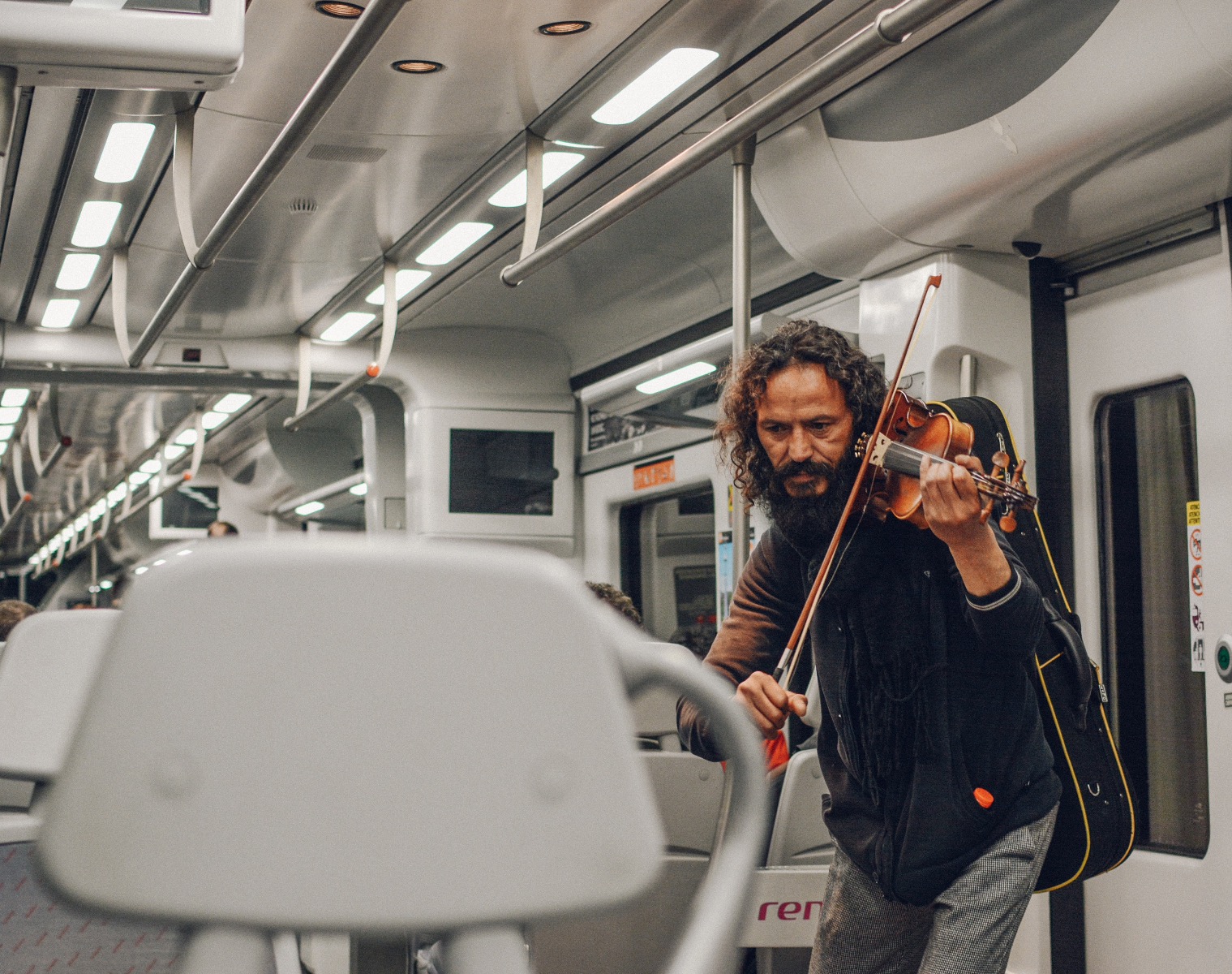 Disheveled man playing violin on the subway