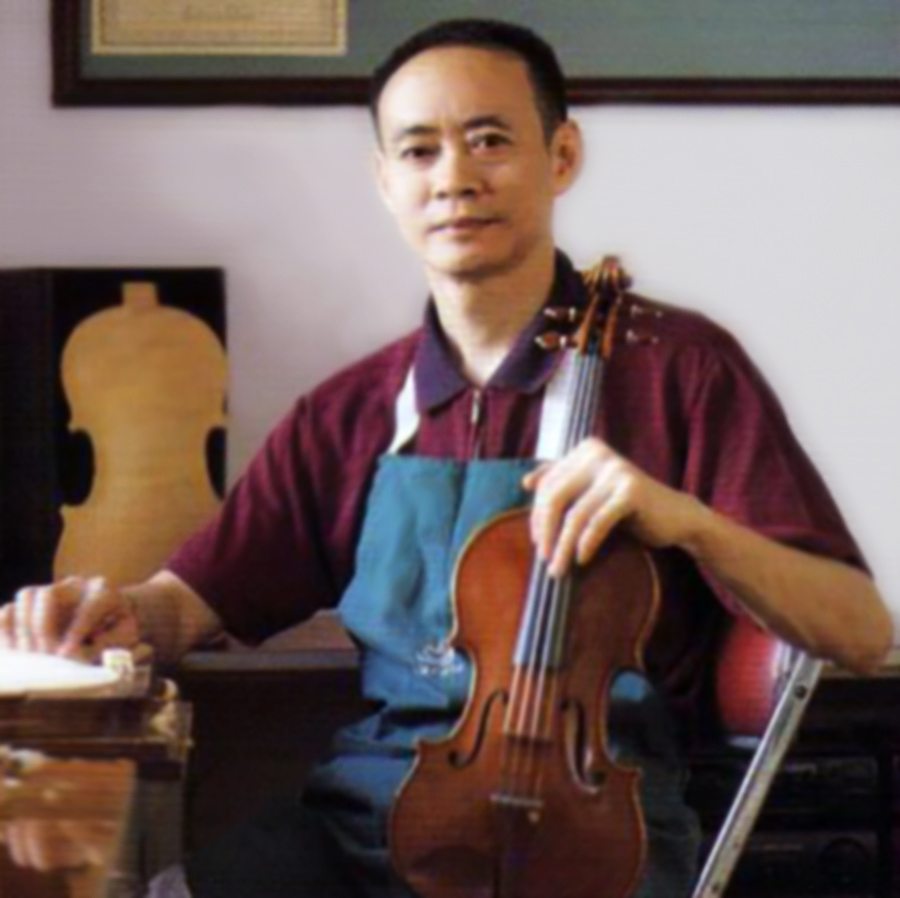 The late Mr. Zhu holding a violin in his studio